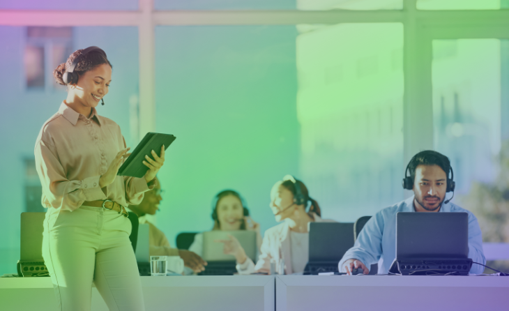 A group of contact centre workers and the contact centre manager looking happy while working.